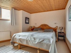 萨伦Chalet Korpstigen Renen - DAN074 by Interhome的一间卧室设有一张带木制天花板的大床