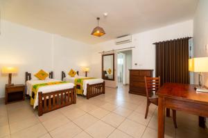 博瓦隆热带的向往公寓式酒店的一间卧室配有两张床、一张桌子和一张书桌