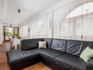 科尔尼奇Holiday Home Noveanni by Interhome的客厅里一张黑色皮沙发,配有桌子