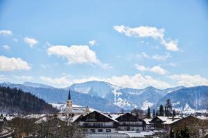 上施陶芬Lindner Hotel Oberstaufen Parkhotel, part of JdV by Hyatt的一座教堂和山丘背景的城镇