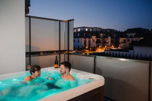 萨尔瓦尔Onyx Luxury的阳台上的浴缸可供两人使用