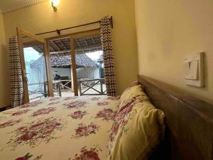 吉汶瓦Bhome Zanzibar的一间卧室配有一张床,享有门廊的景色