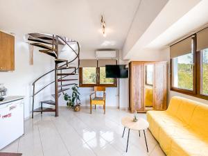 塞雷Studio Acropolis Serres Next to Center的客厅设有黄色沙发和螺旋楼梯。