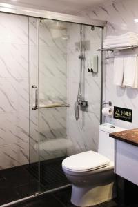铜仁铜仁世纪大酒店的一间带卫生间和玻璃淋浴间的浴室