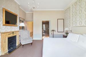 巴塞罗那Hotel El Palace Barcelona的一间卧室设有一张大床和一个壁炉