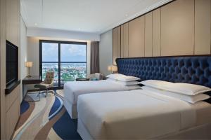 岘港岘港福朋喜来登酒店的酒店客房设有两张床和大窗户。