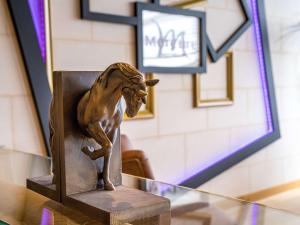 索米尔索米尔卢瓦尔河畔美居酒店的坐在玻璃桌旁的铜狮雕像