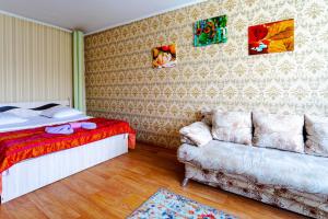 彼得罗巴甫洛夫斯克Мандарин的一间卧室配有一张床和一张沙发