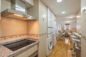 莫纳奇尔Apartamento ladera de Sierra Nevada的厨房配有炉灶、洗衣机和烘干机