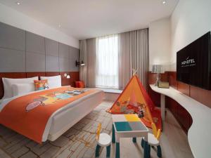 上海上海虹桥会展诺富特酒店的一间卧室配有一张大床和一个玩具帐篷