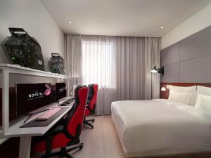 上海上海虹桥会展诺富特酒店的酒店客房配有一张床和一张带电脑的书桌