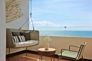 芭堤雅市中心芭提雅安凡尼度假酒店的阳台配有椅子和桌子及桌子