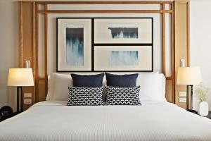 芭堤雅市中心芭提雅安凡尼度假酒店的一间卧室配有一张带两盏灯的大型白色床。