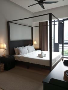 吉隆坡KLCC Beyond Hospitality Suites STAR的一间卧室配有一张大床和吊扇