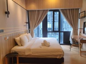 吉隆坡KLCC Ritz Residence STAR的一间卧室配有一张带书桌的床和窗户。
