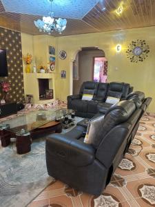 MaralalLoresho cottages的客厅配有真皮沙发和桌子