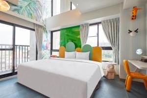 高雄星澄風旅 Zela Design Hotel的卧室配有一张白色大床和一张书桌