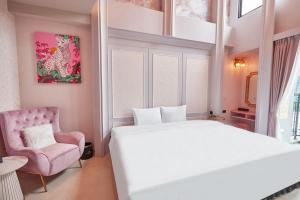 高雄星澄風旅 Zela Design Hotel的卧室配有白色的床和粉红色的椅子