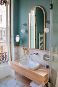 里昂里昂中心美术学院美居酒店的一间带水槽和镜子的浴室