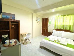 长滩岛WHITEBEACH DE BORACAY STATION 1 (EXTENSION)的一间卧室配有一张床和一张桌子及椅子