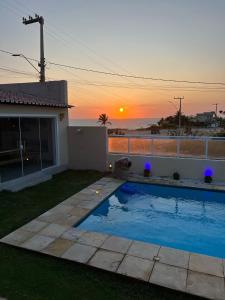 卡诺格布拉达Villa do Nino的庭院内的游泳池,背景是日落