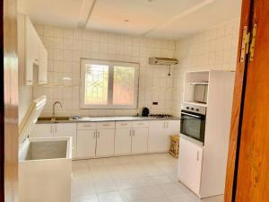 土巴迪亚劳Résidence Toubab的厨房配有白色家电和窗户