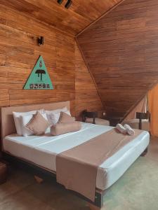哈伯勒内Gabaa Resort & Spa - Habarana的卧室配有一张大床,墙上有标志
