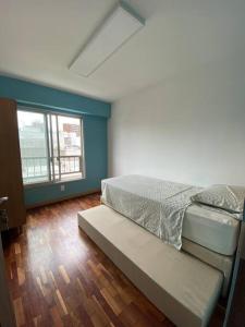 蒙得维的亚Apartamento en Barrio Sur DOS HABITACIONES的一间卧室配有一张床和长凳