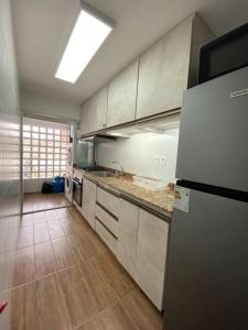 蒙得维的亚Apartamento en Barrio Sur DOS HABITACIONES的厨房配有白色橱柜和冰箱。