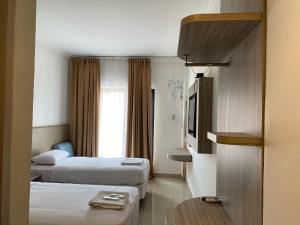 SukaramiBelvena Makati Hotel的酒店客房设有两张床和电视。