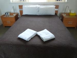 阿德莱德科孚格莱内尔格假日公寓的一间卧室配有一张带两条白色毛巾的床