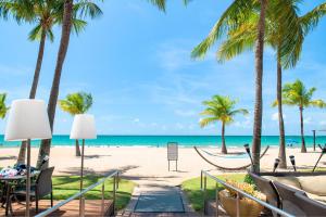 圣胡安佛得岛海滩万豪万怡度假酒店的棕榈树海滩和吊床的景色