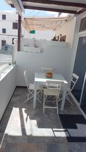 阿列塔CASA FABi GOLONDRINA HOUSE的阳台上配有白色的桌椅