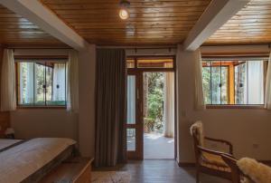 蒙特韦尔迪Pousada Canto da Nascente的一间卧室设有床和滑动玻璃门