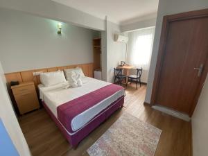 伊斯坦布尔HOTEL ÖZSEFA的卧室配有床、桌子和门