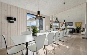 哈夫維格Amazing Home In Hvide Sande With House A Panoramic View的一间带长桌和椅子的用餐室