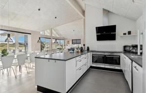 哈夫維格Amazing Home In Hvide Sande With House A Panoramic View的厨房配有白色橱柜和黑色台面