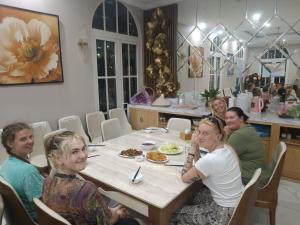 下龙湾Huong Duong Sunflower的一群坐在餐桌上吃食物的妇女