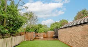 RamseyExtensive 4 bed close to Peterborough的后院设有砖墙和草坪