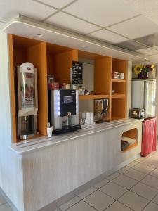 拉库罗讷普瑞米尔昂古勒姆拉库洛那经典酒店的一间带咖啡机的柜台的咖啡店