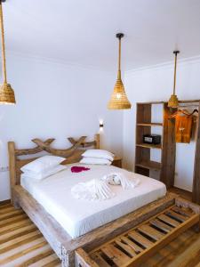 南威Limiria Villa Zanzibar的一间卧室配有一张带白色床单和吊灯的床。