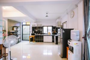 清迈LD8 House Private Pool Perfect Groups -Families ChiangMai的厨房铺有白色地板,配有黑色冰箱。
