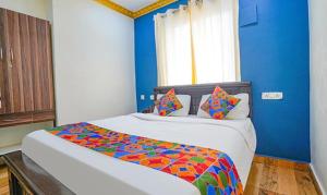 钦奈FabExpress Lloyds Inn的一间卧室配有一张大床和色彩缤纷的被子