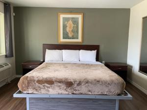 帕里斯Paris Extended Stay Suites的一间卧室配有一张带2个床头柜的大床