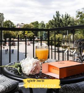 敖德萨德利巴斯酒店的一张桌子,上面放着一杯橙汁,还有一本书和酒杯