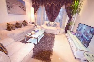 科威特Hotel Leaders Plaza Mahboula的客厅配有两张沙发和一台电视机