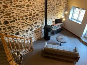 Saint-DiéryLa clé des champs de Laumont的带沙发和石墙的客厅