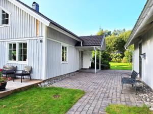 HärrydaFresh villa in Harryda near Landvetter airport and golf course的一个带两把椅子的庭院和一座房子