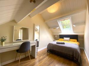 莫珀斯Morpeth town centre - Cottingburn House的一间卧室配有一张床、一张书桌和一面镜子