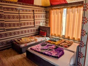 瓦迪拉姆Wadi Rum Camp & Jeep Tour的带窗帘的客房内配有两张床的房间